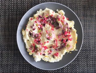 Saffraan labneh met een topping van granaatappel, pistachenootjes en bloemen